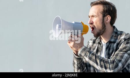 Vue de face jeune homme avec mégaphone Banque D'Images