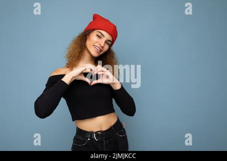 Photo de joli beau chattage attrayant sourire heureux frais jeune mauriquement sombre blonde femme debout isolée sur le dos bleu Banque D'Images