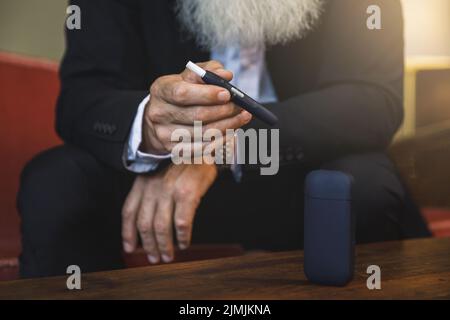 Homme avec un système de chauffage du tabac dans ses mains Banque D'Images