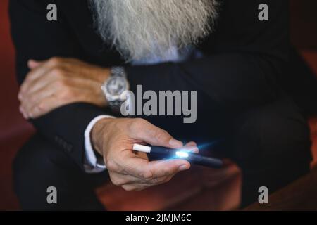 Homme avec un système de chauffage du tabac dans ses mains Banque D'Images