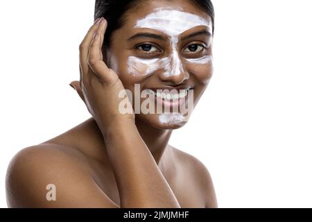 Jeune femme indienne avec un masque de nettoyage appliqué sur son visage Banque D'Images