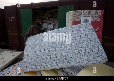 Peshawar, Khyber Pakhtunkhwa, Pakistan. 5th août 2022. Les travailleurs chargent du matériel de secours sur un train pour que les victimes des inondations soient envoyées dans les zones frappées par les inondations de la province du Baloutchistan depuis le gouvernement Khyber Pakhtunkhwa à Peshawar. Au moins 357 personnes ont perdu la vie, dont 140 enfants, et 408 autres ont été blessées par des pluies et des inondations soudaines depuis le début de la saison de la mousson, selon l'Autorité nationale de gestion des catastrophes (NDMA). Le Pakistan figure parmi les 10 pays les plus vulnérables au changement climatique. (Image de crédit : © Hussain Ali/Pacific Press via ZUMA Press Wire) Banque D'Images