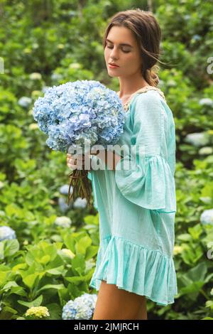 Jeune et belle femme fleuriste collectant des fleurs d'Hydrangea Banque D'Images