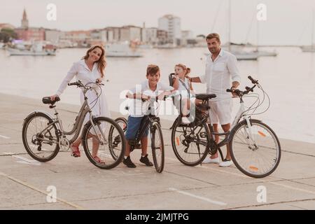 La famille heureuse profite d'une belle matinée au bord de la mer à vélo et à passer du temps ensemble. Le concept d'un heureux Banque D'Images