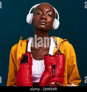Rien ne se situe entre moi et mes objectifs. Portrait court d'un joli boxeur féminin debout seul et posé avec un casque contre un Banque D'Images