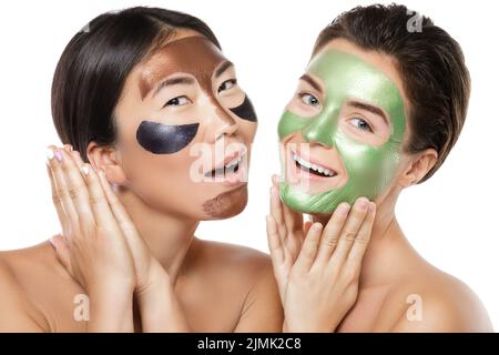 Deux belles filles avec des masques de décollement colorés sur leur visage Banque D'Images