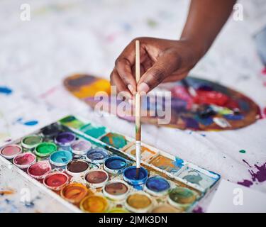 Faites l'art chaque jour. Une femme méconnaissable utilisant un pinceau et une palette de peinture. Banque D'Images