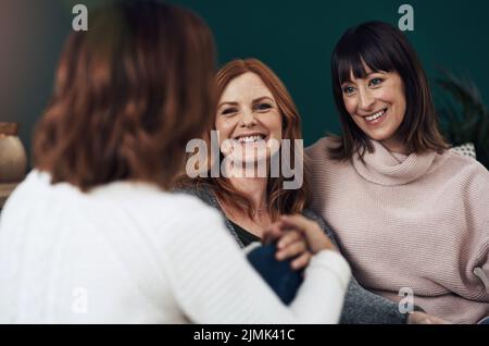 Voici les derniers potins : trois femmes d'âge moyen qui ont une discussion à la maison pendant la journée. Banque D'Images