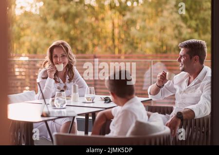 Un couple âgé bénéficie de la terrasse d'une maison de luxe avec son fils pendant les vacances. Mise au point sélective Banque D'Images