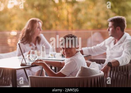 Un couple âgé bénéficie de la terrasse d'une maison de luxe avec son fils pendant les vacances. Mise au point sélective Banque D'Images