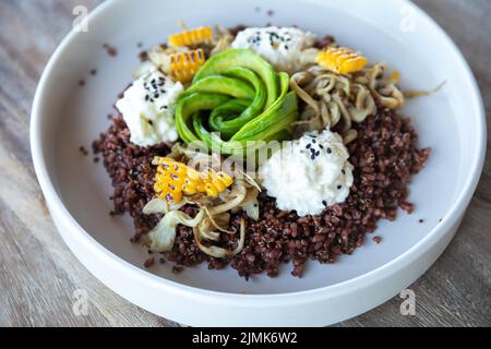 Délicieux plat avec avocat, fromage, maïs et grains de blé germés. Banque D'Images