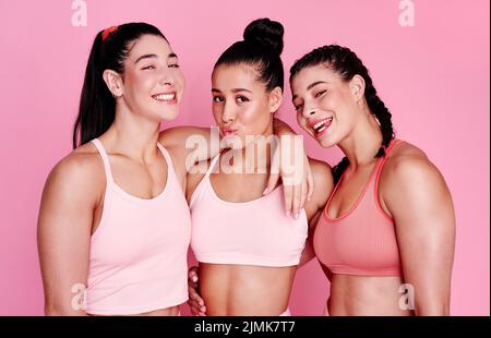 Devenir des femmes fortes et belles. Portrait en studio d'un groupe de jeunes femmes sportives debout ensemble sur fond rose. Banque D'Images