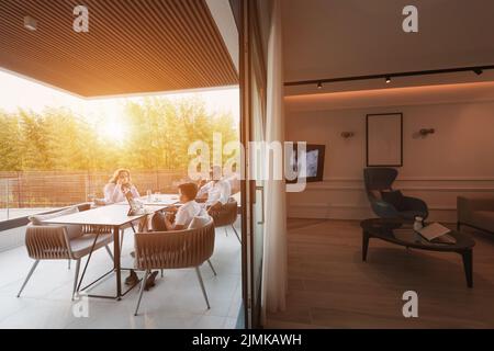 Un couple âgé bénéficie de la terrasse d'une maison de luxe avec son fils pendant les vacances. Mise au point sélective Banque D'Images