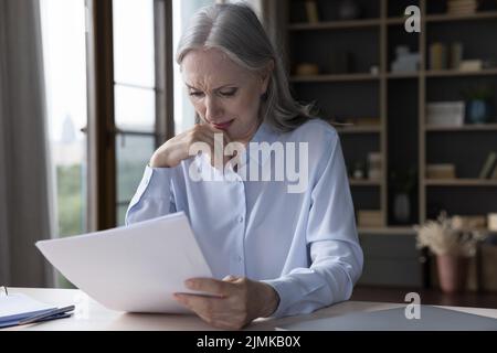 Triste femme d'affaires âgée recevant de mauvaises nouvelles choquantes au sujet de la perte Banque D'Images