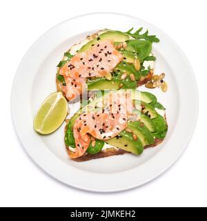 Toasts d'avocat, de saumon et de fromage à la crème fraîchement préparés, isolés sur fond blanc Banque D'Images