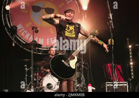 Ken Bonsall, chanteur et guitariste avec le groupe folk britannique Ferocious Dog vu en live sur scène au festival Wickham. Ferocious Dog est un groupe de six musiciens qui s'occupe d'une veine vibrante de punk rock infusé par le peuple celtique, qui s'enjambe confortablement entre Billy Bragg et The Levelers. Le groupe a des visites guidées du Royaume-Uni et de l'Europe, au Kenya et à Dubaï, des festivals comme Bearded Theory, Alchemy, Deerstock, Farmer Phil Festival, Splendor, Lowlands (pays-Bas), Festival de Glastonbury et beaux jours parmi beaucoup d'autres. Banque D'Images