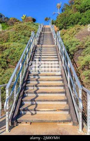 Escaliers extérieurs avec marches en bois et rambardes en métal à San Clemente, Californie. Escaliers sur une pente d'une montagne contre le ciel clair. Banque D'Images