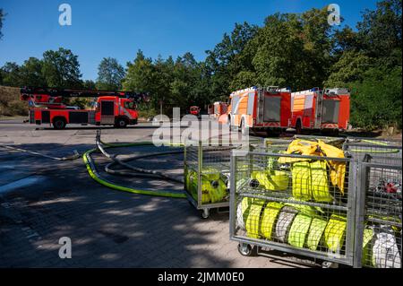 Berlin, Allemagne. 07th août 2022. Des moteurs d'incendie se trouvent près du lieu de l'incendie au site de dynamitage de la police de Berlin à Grunewald. Jeudi 04.08.2022, un incendie avait éclaté sur le site de dynamitage. Le site de dynamitage stocke les munitions que les experts en la matière rendent normalement inoffensives. Malgré l'effet initial des mesures d'extinction, l'incendie au Grunewald de Berlin demeure un « danger énorme » de l'avis du service des incendies. Credit: Christophe bateau/dpa/Alay Live News Banque D'Images
