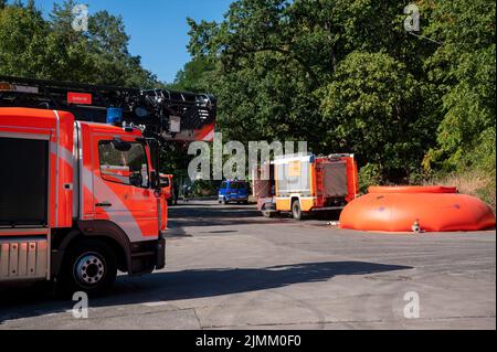 Berlin, Allemagne. 07th août 2022. Des pompiers et des véhicules de police se trouvent près du lieu de l'incendie au site de dynamitage de la police de Berlin à Grunewald. Jeudi 04.08.2022, un incendie avait éclaté sur le site de dynamitage. Le site de dynamitage stocke les munitions que les experts en la matière rendent normalement inoffensives. Malgré l'effet initial des mesures d'extinction, l'incendie au Grunewald de Berlin demeure un « danger énorme » de l'avis du service des incendies. Credit: Christophe bateau/dpa/Alay Live News Banque D'Images