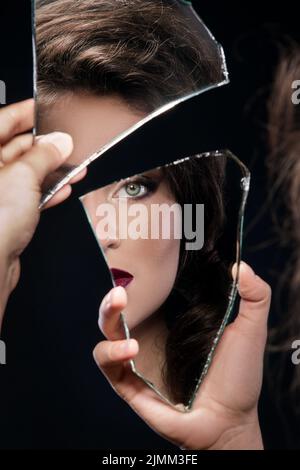 Femme regardant dans le morceau de miroir Banque D'Images