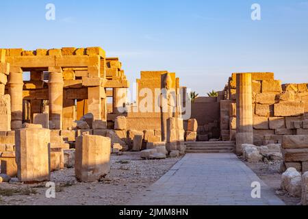 Statue de Pharaon Ramses II debout devant les ruines du temple. Banque D'Images