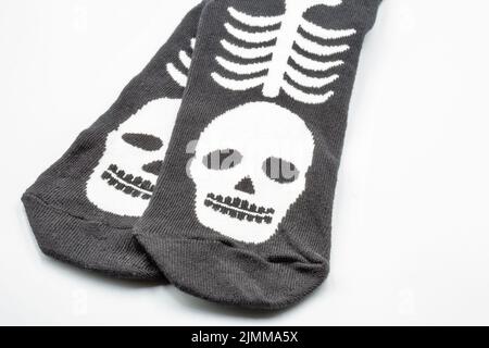 Chaussettes noires avec squelette mouette blanc gros plan sur blanc. Imprimé sur le thème de l'Halloween. Banque D'Images