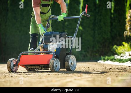 Aérateur de pelouse de paysagiste. Préparation du terrain pour l'ensemencement d'herbe. Banque D'Images