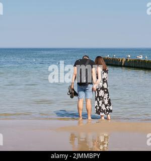 Jeune couple marchant sur la plage de la mer Baltique près de Kolobrzeg en Pologne Banque D'Images