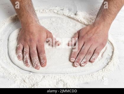 Homme grand angle pétriant la pâte à pizza Banque D'Images