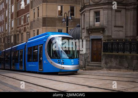 Birmingham UK moderne Blue City tram transports publics qui traversent le centre de la ville en passant par les vieux bâtiments. Banque D'Images