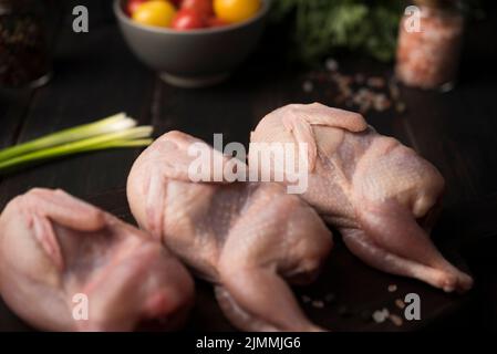 Gros plan sur le panneau de bois de poulet cru avec les ingrédients Banque D'Images