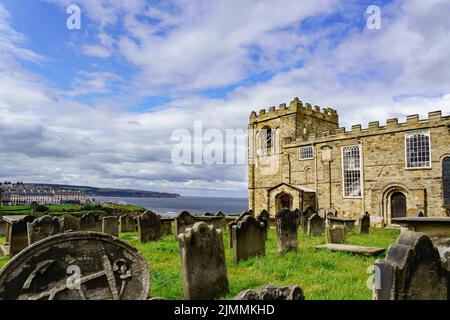 L'église Whitby de Saint Mary, avec son cimetière, ses pierres de tête et sa mer en arrière-plan, est construite sur la falaise est dans le North Yorkshire, Angleterre, Royaume-Uni. Banque D'Images