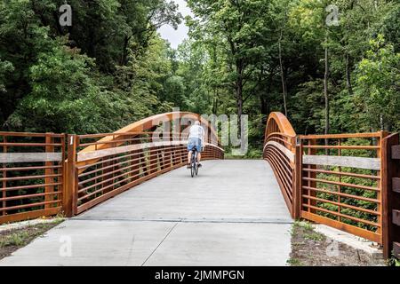 Un homme qui traverse son vélo au-dessus du pont n° 1 sur le sentier régional suédois de l'immigrant qui va de Taylors Falls à Shafer, Minnesota, États-Unis. Banque D'Images