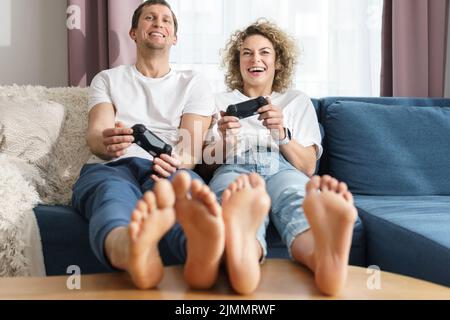 Couple avec un gamepads jouent à la console de jeux vidéo à la maison Banque D'Images