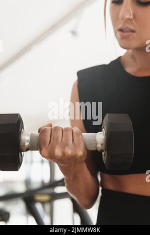 Main femelle avec une haltère pendant l'exercice de boucle de biceps Banque D'Images