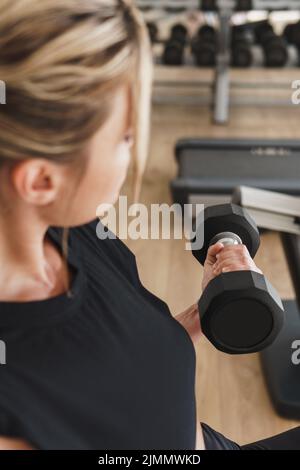 Main femelle avec une haltère pendant l'exercice de boucle de biceps Banque D'Images