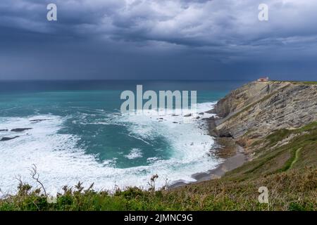 Vue sur le phare sur les falaises de Cabo Vidio sous un ciel couvert et orageux Banque D'Images