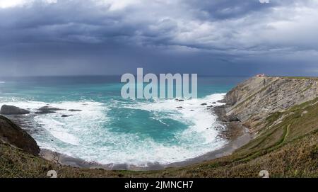 Vue sur le phare sur les falaises de Cabo Vidio sous un ciel couvert et orageux Banque D'Images