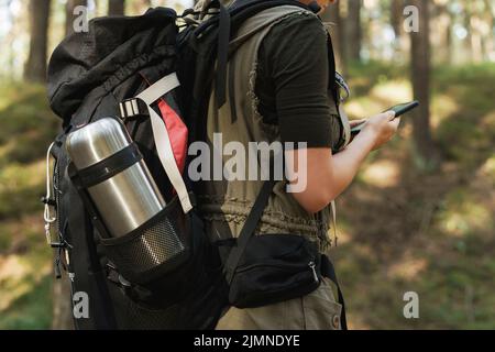 Randonneur féminin avec grand sac à dos dans la forêt verte Banque D'Images