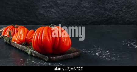 Un groupe de grosses tomates Costoluto avec origan sur fond gris, espace pour le texte Banque D'Images