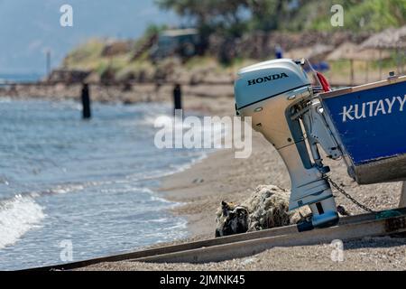 Moteur de bateau extérieur Honda à l'arrière d'un petit bateau débarqué sur la plage. Banque D'Images