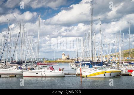 Phare de Howth vu à travers des mâts de voiliers et de yachts amarrés dans la marina de Howth Banque D'Images