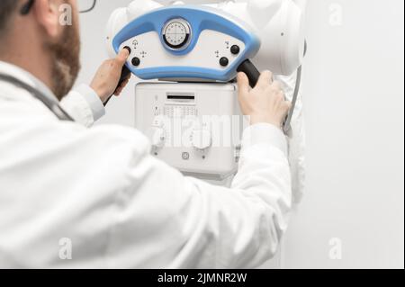 Médecin exploitant un appareil à rayons X dans le service de radiologie Banque D'Images