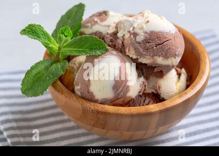 Glace au chocolat et à la vanille dans un bol en bois. Banque D'Images