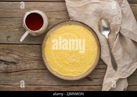 Polenta de porridge avec tasse de thé, fond en bois sombre, vue du dessus Banque D'Images