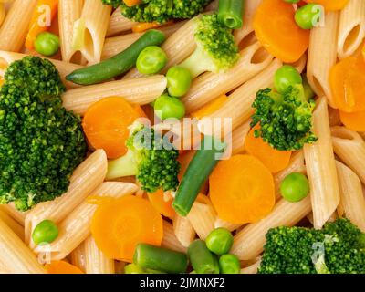 Pâtes de blé entier Penne avec brocoli, carottes, pois verts. Gros plan, macro. Menu de régime Banque D'Images