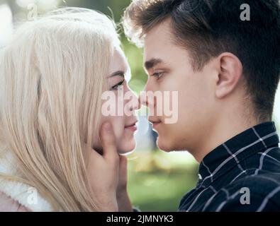 Un homme appelle affectueusement regarde la femme, le gars et la fille valent la peine de près, touchant les bouts nez. Concept de l'amour et du sapin adolescents Banque D'Images