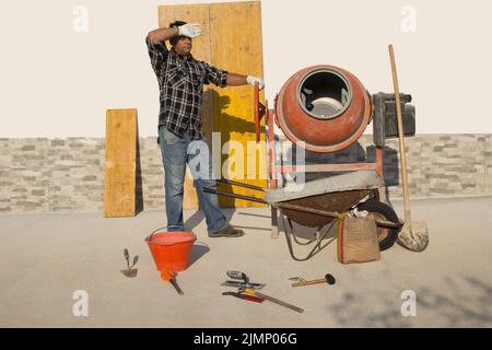 Bricklayer essuyant la transpiration dans le soleil flamboyant tout en mélangeant le béton avec un mélangeur de ciment sur un chantier de construction Banque D'Images