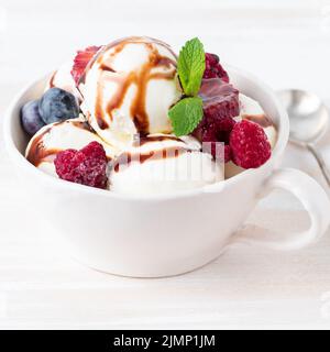 Boules de glace vanille en tasse avec framboise et bleuets, chocolat Banque D'Images