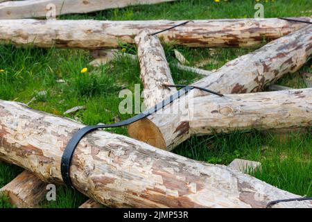 connexion à bande en acier forgé de poutres en bois pour cadre de poutre de support de toit posé sur l'herbe verte le jour d'été pendant l'assemblage Banque D'Images